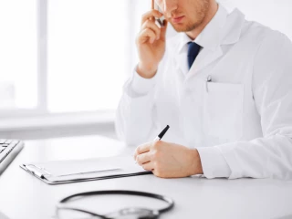 mlady lékař telefonuje a píše recept pracuje
