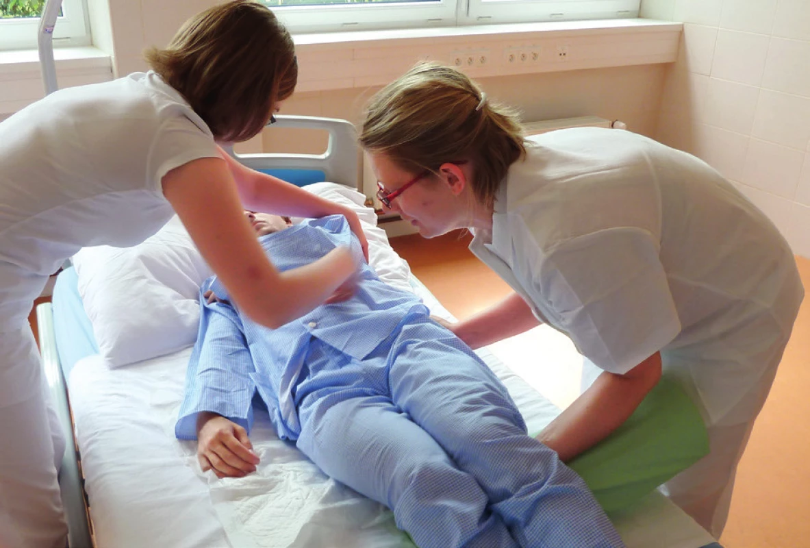 Celý manévr může být usnadněn použitím válcové podložky, která usnadní udržení dolních končetin ve flexi. Na stranu, na kterou bude nemocný otáčen, však nesmí podložka zpod kolen přesahovat, aby v další fázi manévru otáčení těla nebránila.