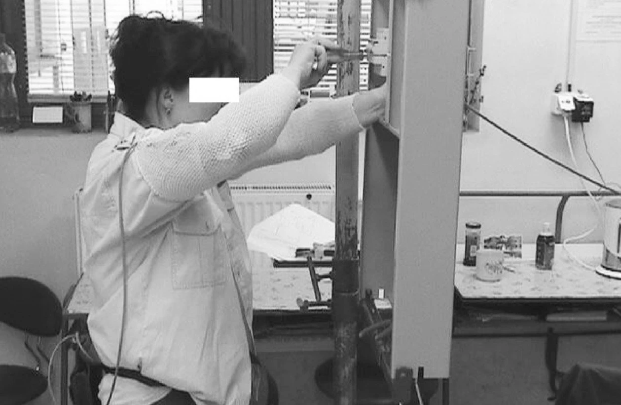 Poloha horních končetin při zapojování kabelů na svislém panelu u elektromechaničky Výškové nastavení panelu je možné, není využíváno.