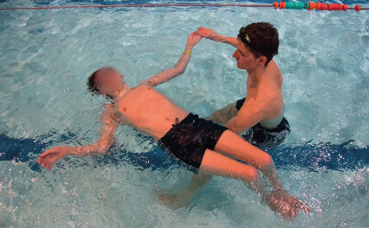 Kolotoč – plavec leží na zádech, instruktor stojí po
boku plavce, otočený k jeho hlavě, ruka blíže k plavci podepírá
plavcova bedra, druhou rukou uchopí HK plavce, navede ji do
90° abdukce a začne se s plavcem otáčet dokola ve směru, který ukazuje abdukovaná paže (10) (vlastní zdroj).